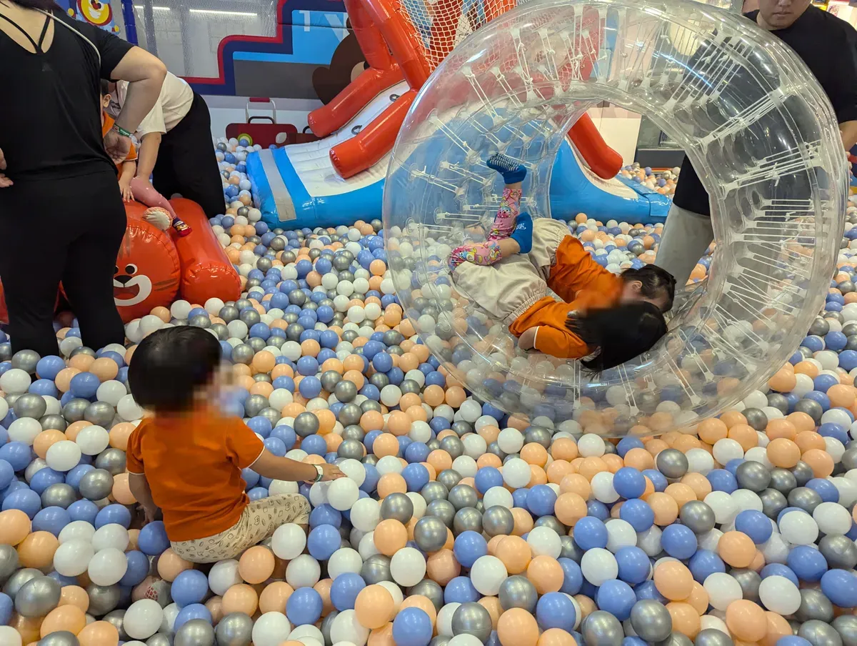 Children in the large ball pit at Kiztopia, Jewel Changi, one rolling inside an inflatable wheel.