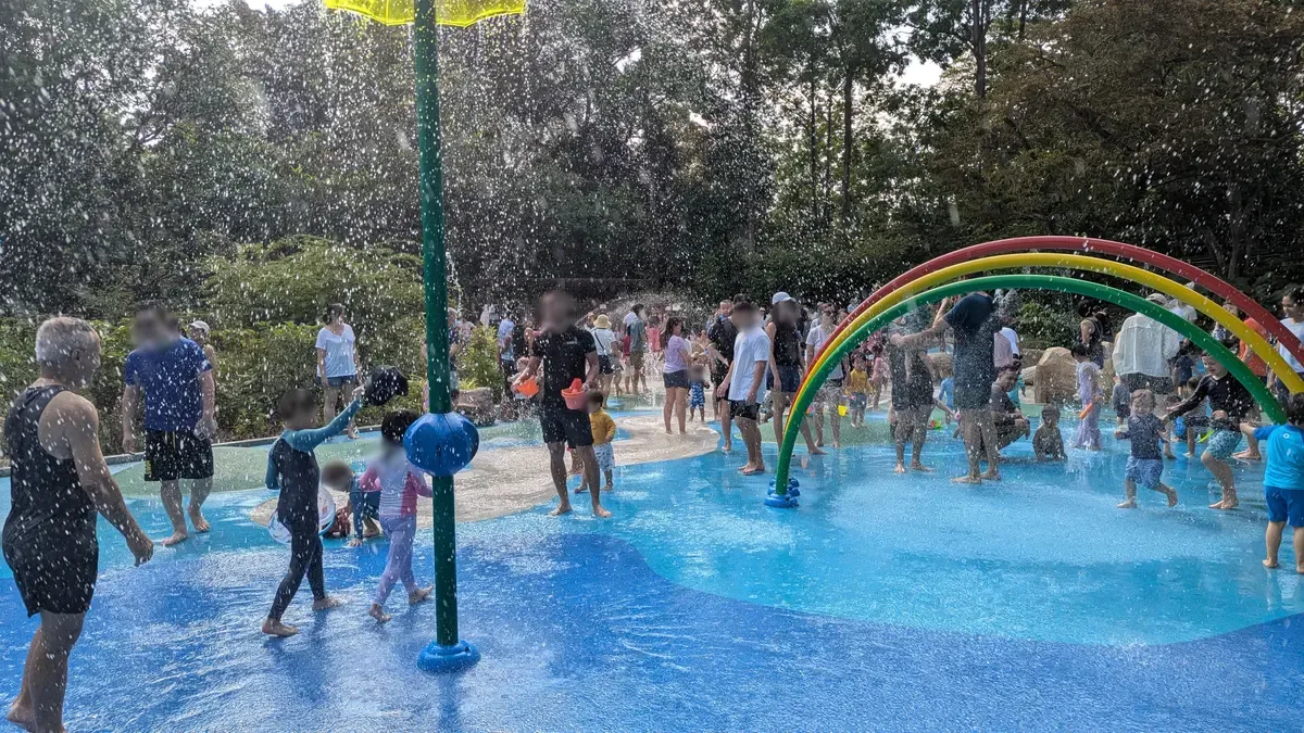 The rainbow-arch sprinkler and busy splash pad at Jacob Ballas Children’s Garden.